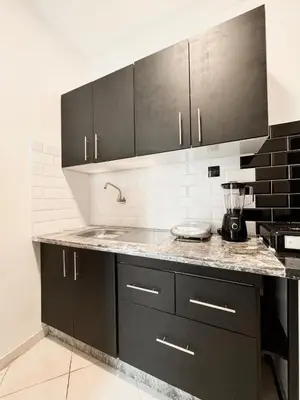a kitchen with black cabinets and a counter top at Budget-Friendly 2BR - AC and heating in All Rooms in Marrakech