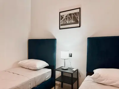 a room with two beds and a lamp on a table at Budget-Friendly 2BR - AC and heating in All Rooms in Marrakech