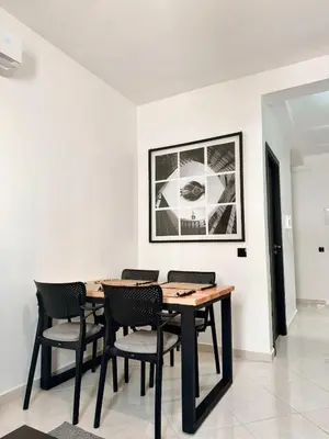 a dining room with a wooden table and chairs at Budget-Friendly 2BR - AC and heating in All Rooms in Marrakech