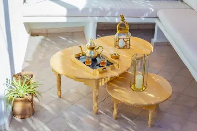a table with two chairs and a lamp on a balcony at Riad JONCHÈRES in Marrakech