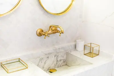 a bathroom with a sink and a gold faucet at Riad JONCHÈRES in Marrakech