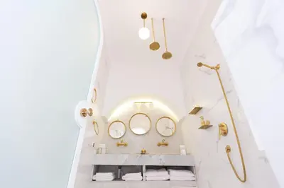 a bathroom with white walls and a sink with mirrors at Riad JONCHÈRES in Marrakech
