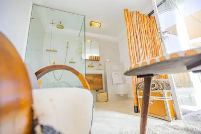 a bathroom with a shower and a bed in a room at Riad JONCHÈRES in Marrakech