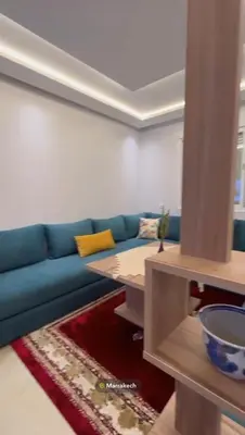 a living room with a blue couch and a table at Appartement in Marrakech
