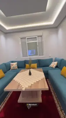 a living room with a blue couch and a table at Appartement in Marrakech
