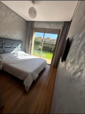 a bedroom with a large bed and a large window at Prestigia Jubaea Marrakech Argane in Marrakech