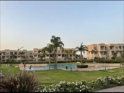 a resort with a pool and palm trees and buildings at Prestigia Jubaea Marrakech Argane in Marrakech