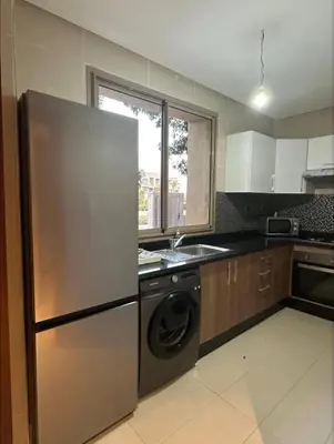 a kitchen with a stainless steel refrigerator and a dishwasher at Prestigia Jubaea Marrakech Argane in Marrakech