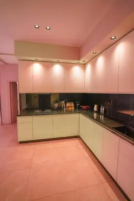 a kitchen with white cabinets and black counter tops at Golf el maaden Splendide villa in Marrakech