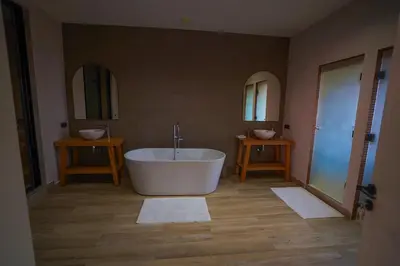 a bathroom with a large tub and two mirrors at Golf el maaden Splendide villa in Marrakech