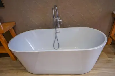 a white bath tub with a shower in a bathroom at Golf el maaden Splendide villa in Marrakech