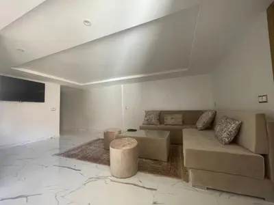 a living room with a couch and a table at Cosy appartement downtown gueliz in Marrakech