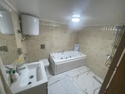 a bathroom with a tub and a toilet and a sink at Cosy appartement downtown gueliz in Marrakech