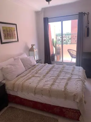 a large bed in a bedroom with a window at BEL APPARTEMENT CENTRE MARRAKECH GUELIz in Marrakech