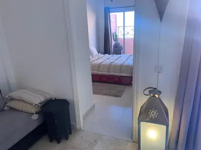 a room with a bedroom with a bed and a mirror at BEL APPARTEMENT CENTRE MARRAKECH GUELIz in Marrakech