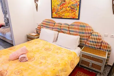 a bedroom with a large bed and a chair at Riad GALFANE in Marrakech