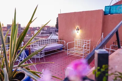 a balcony with chairs and a bench on a building at Riad GALFANE in Marrakech