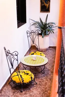a table and two chairs and a table and a plant at Riad GALFANE in Marrakech