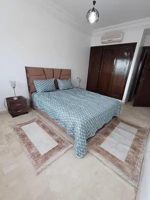 a bedroom with a bed with two rugs on it at Picasso - Appartement 1 chambre in Marrakech