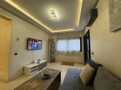 a living room with a couch and a table at Appartement avec piscine en plein centre de Marrakech in Marrakech
