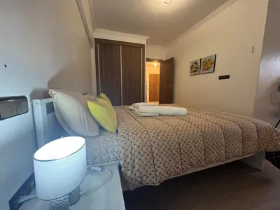 a small bedroom with a bed with pillows and a table at Appartement avec piscine en plein centre de Marrakech in Marrakech