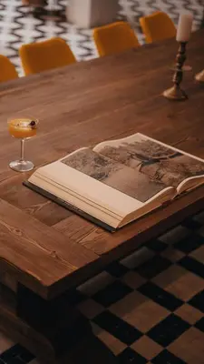 an open book on a wooden table with a wine glass at The Mellah Hotel in Marrakech