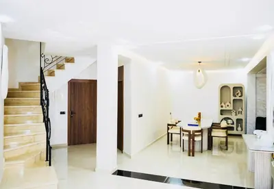 a dining room and living room with a table and chairs at Vaste duplex neuf modernes et raffiné in Marrakech