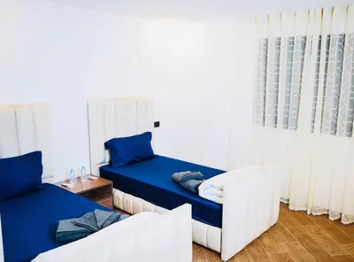 a bedroom with a bed and a couch and a window at Vaste duplex neuf modernes et raffiné in Marrakech
