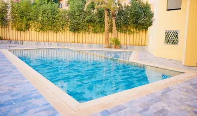 a swimming pool with blue water and a fence at Vaste duplex neuf modernes et raffiné in Marrakech