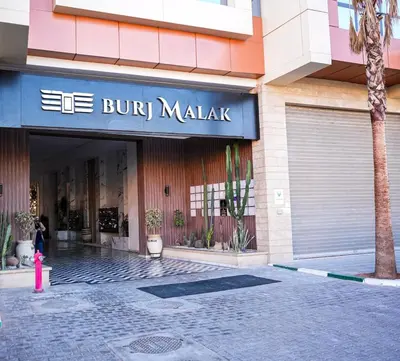 a building with a sign that reads bu but malaza at Vaste duplex neuf modernes et raffiné in Marrakech