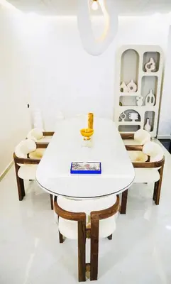 a dining room with a white table and chairs at Vaste duplex neuf modernes et raffiné in Marrakech