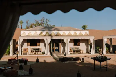 a building with a pavilion with chairs and tables at Palmeraie Oasis Camp - A member of Barcelo Hotel Group in Marrakech
