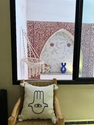 a pillow sitting on a chair in front of a window at Bleu Majorelle, cœur de Gueliz in Marrakech