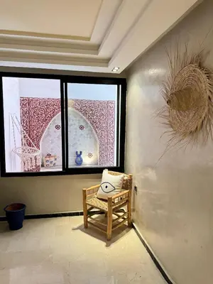 a room with a chair in front of a window at Bleu Majorelle, cœur de Gueliz in Marrakech