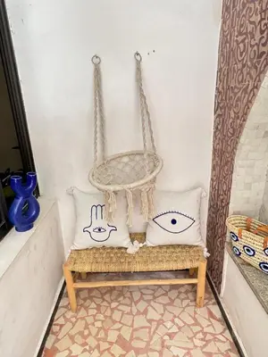 a room with a chair and two pillows on a bench at Bleu Majorelle, cœur de Gueliz in Marrakech