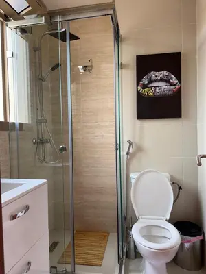 a bathroom with a toilet and a glass shower at Appartement cosy pour 4 personnes in Marrakech