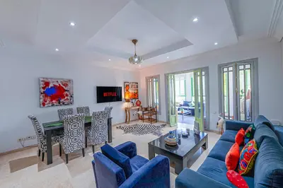 a living room with a blue couch and a table at Luxury Apartment with Pool Large Terrace & Balconies in Hivernage Marrakech in Marrakech