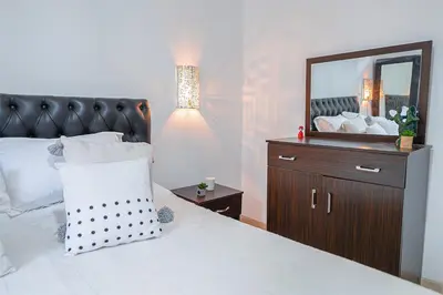 a bedroom with a bed with a mirror and a dresser at Luxury Apartment with Pool Large Terrace & Balconies in Hivernage Marrakech in Marrakech