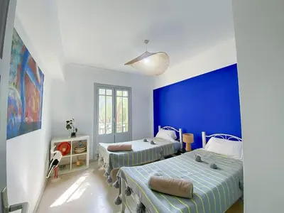 a bedroom with two beds and a blue wall at Luxury Apartment with Pool Large Terrace & Balconies in Hivernage Marrakech in Marrakech