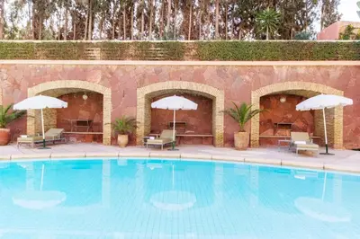 a large swimming pool with chairs and umbrellas at Luxury Apartment with Pool Large Terrace & Balconies in Hivernage Marrakech in Marrakech