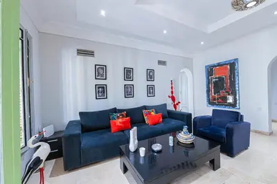 a living room with a blue couch and a coffee table at Luxury Apartment with Pool Large Terrace & Balconies in Hivernage Marrakech in Marrakech