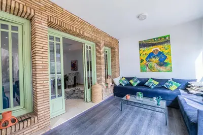 a living room with a blue couch and a brick wall at Luxury Apartment with Pool Large Terrace & Balconies in Hivernage Marrakech in Marrakech