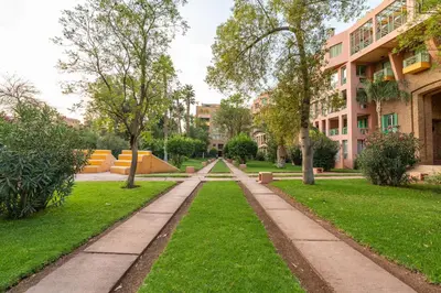 a walkway through a park with buildings at Luxury Apartment with Pool Large Terrace & Balconies in Hivernage Marrakech in Marrakech