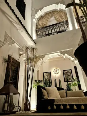 a living room with a couch and a clock on the wall at Riad Dar El Mahja in Marrakech