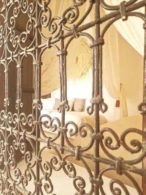 an iron gate leading to a bed in a bedroom at Riad Dar El Mahja in Marrakech