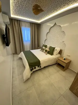 a bedroom with a large bed and a television at Riad De Luxe Marrakech in Marrakech