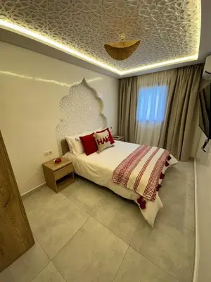 a bedroom with a bed with red pillows on it at Riad De Luxe Marrakech in Marrakech