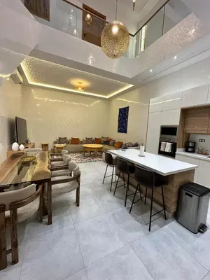 a large living room with a table and chairs at Riad De Luxe Marrakech in Marrakech