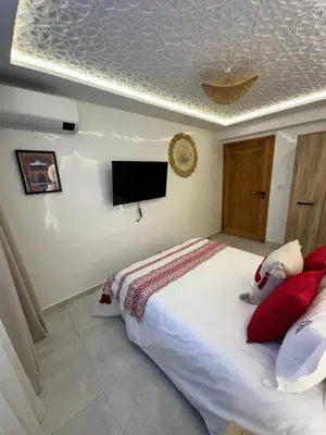 a bedroom with a large bed and a flat screen tv at Riad De Luxe Marrakech in Marrakech