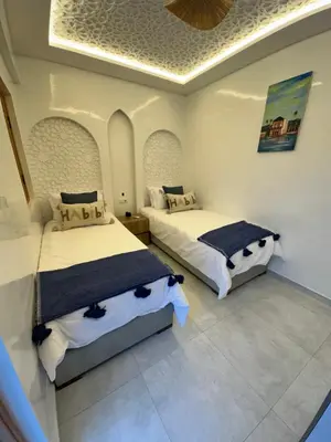 a bedroom with two beds and a ceiling at Riad De Luxe Marrakech in Marrakech